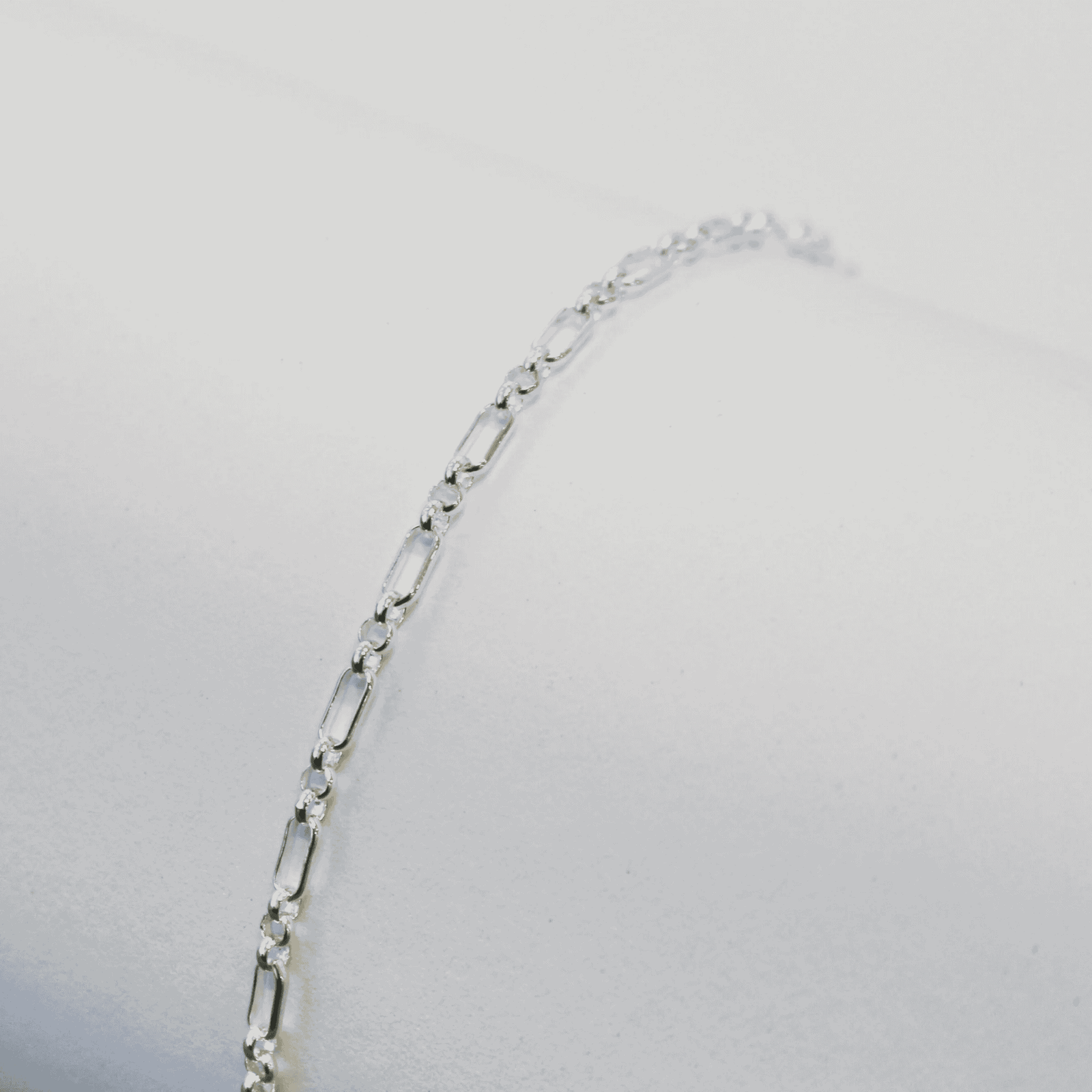 Silver bracelet on a light gray background