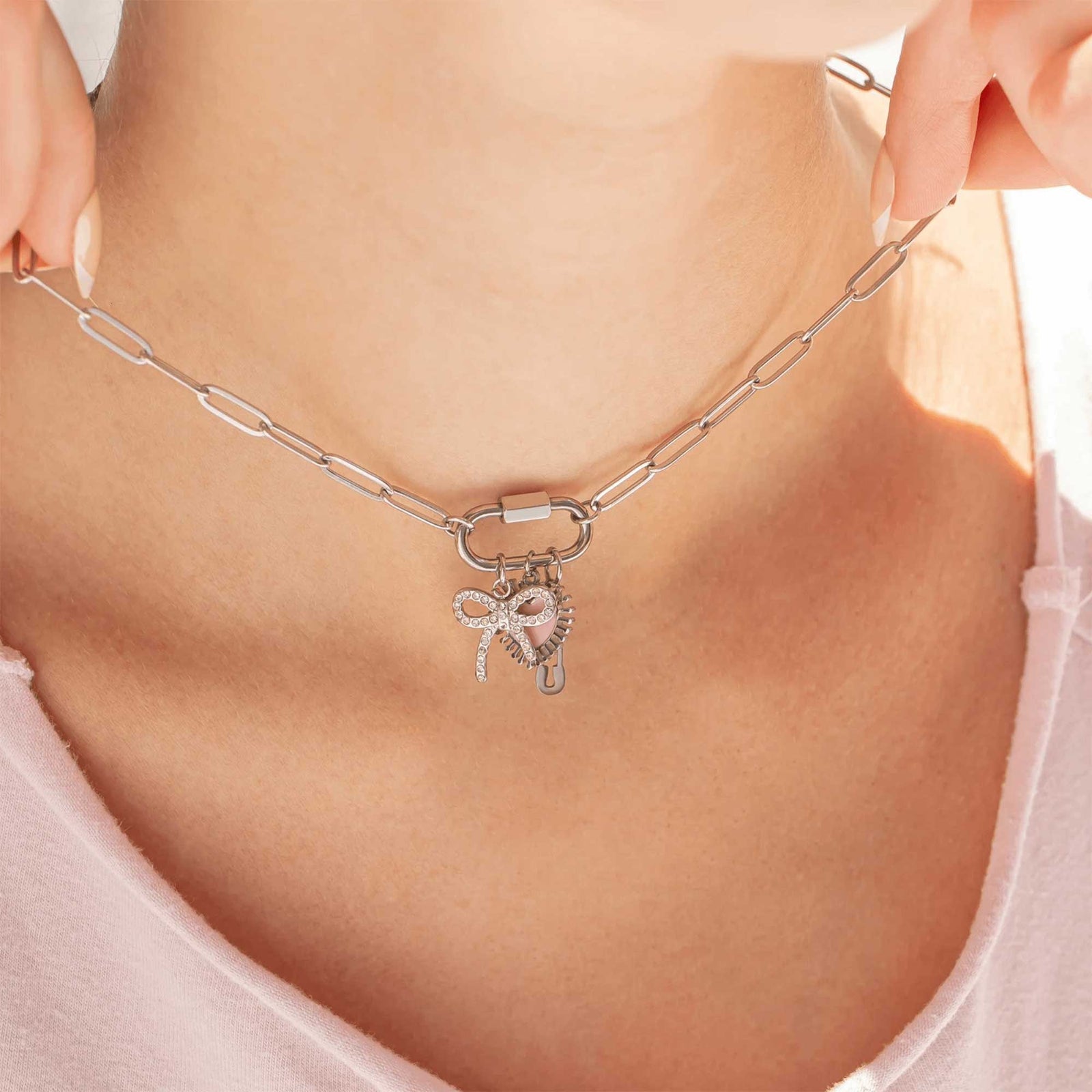 Silver chain necklace with bow charm worn by a person