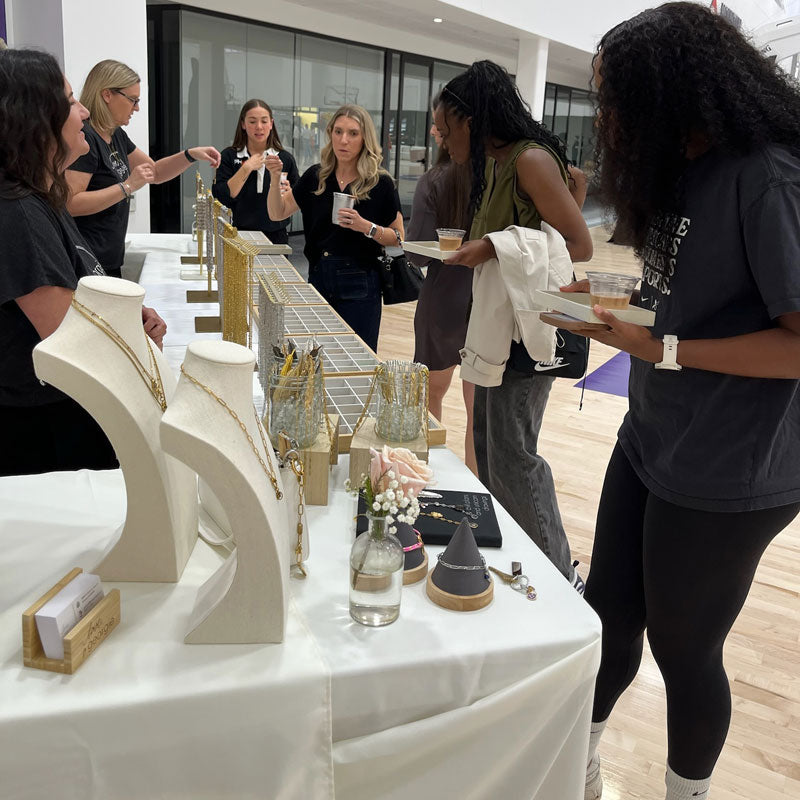 Group of people interacting around a charm bar table.