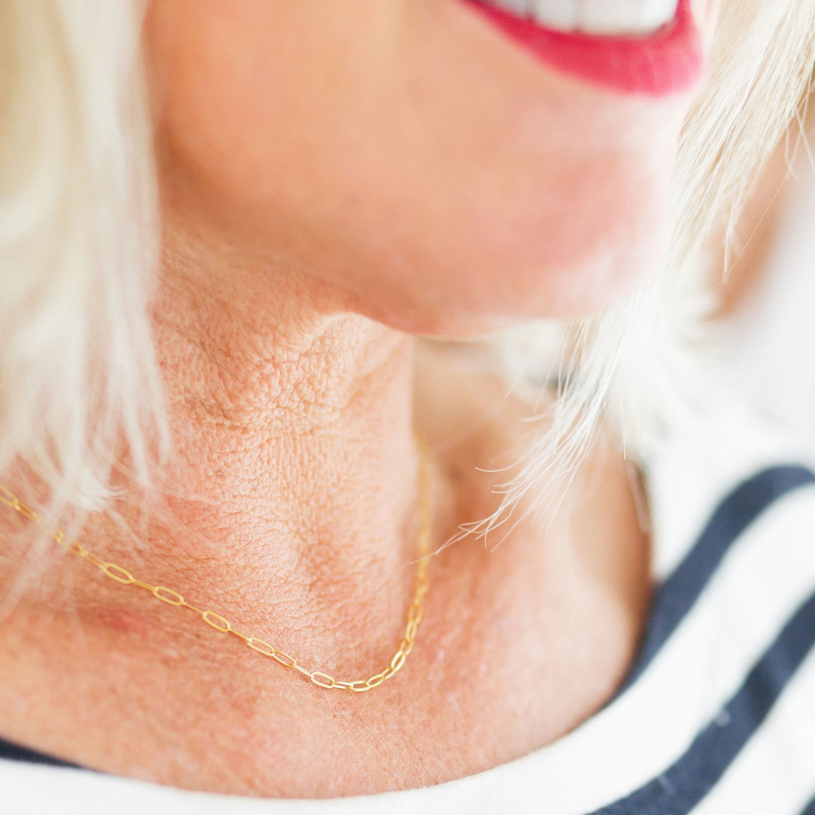 Close-up of a person wearing a gold chain necklace.
