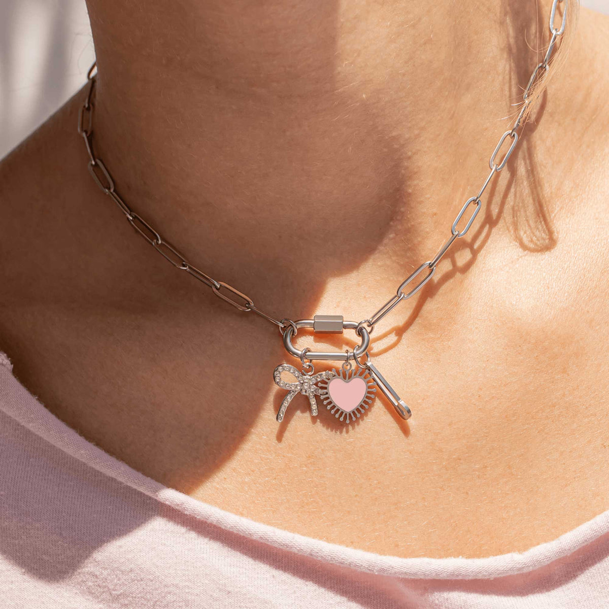 Necklace with charms on a person wearing a light pink top