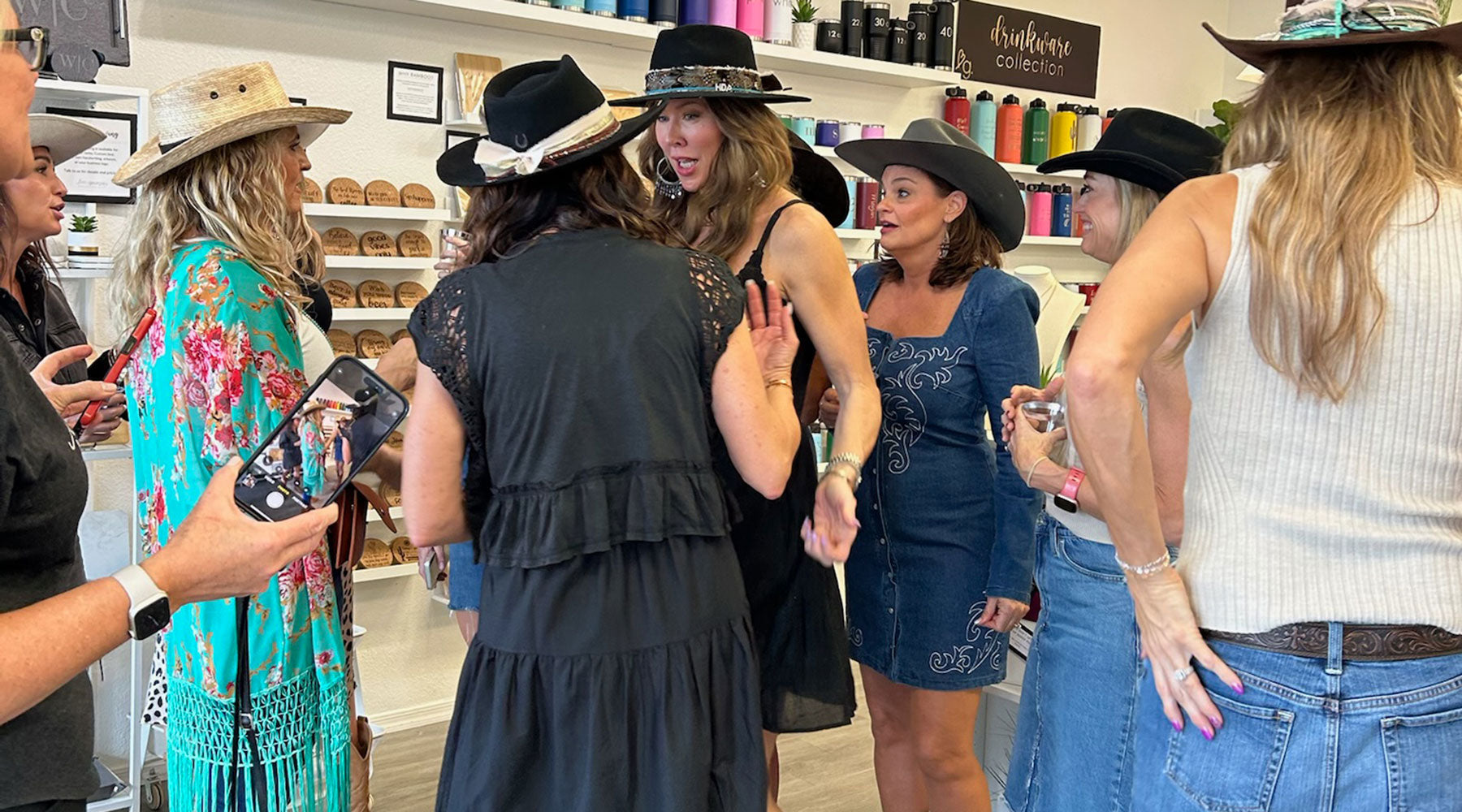 Group of women in Love, Georgie's store wearing hats and interacting with each other.