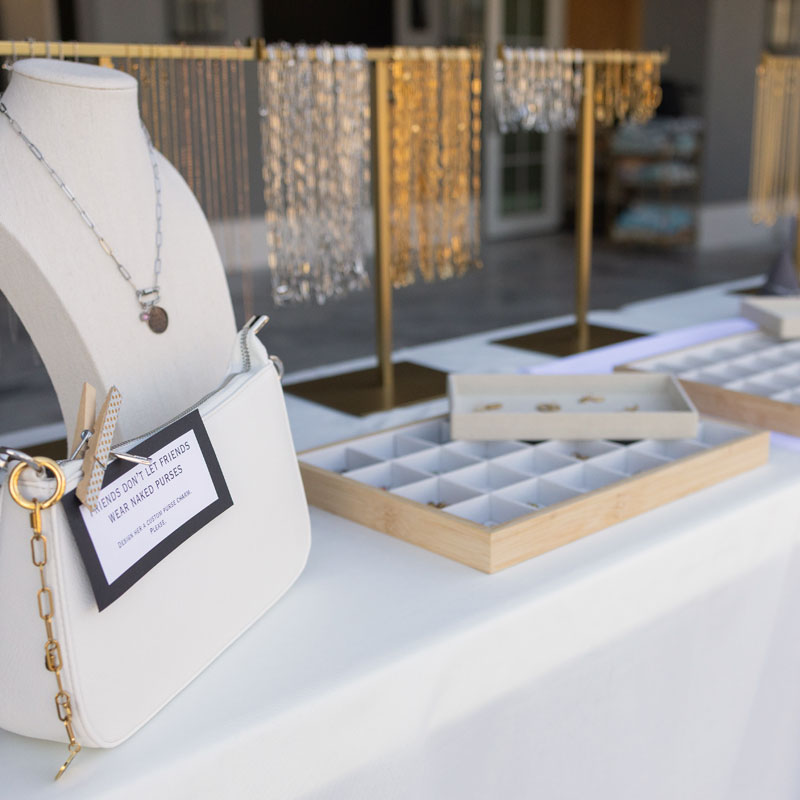 Jewelry display with necklaces on mannequin and table, blurred background