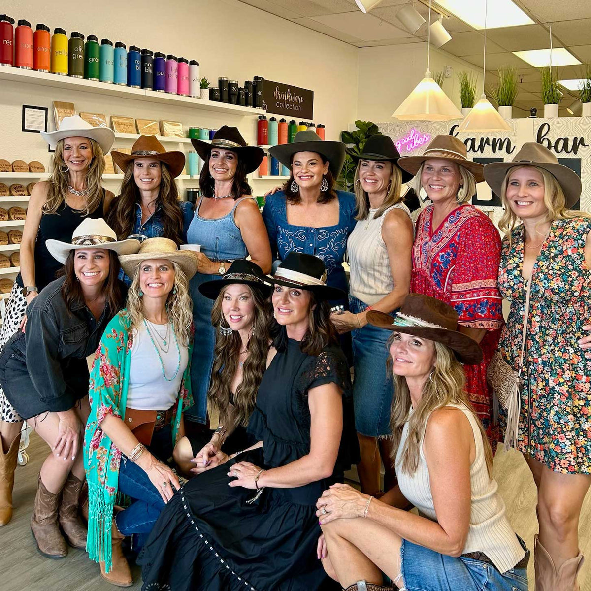 Group of women wearing cowboy hats in Love, Georgie's store with shelves of products in the background.