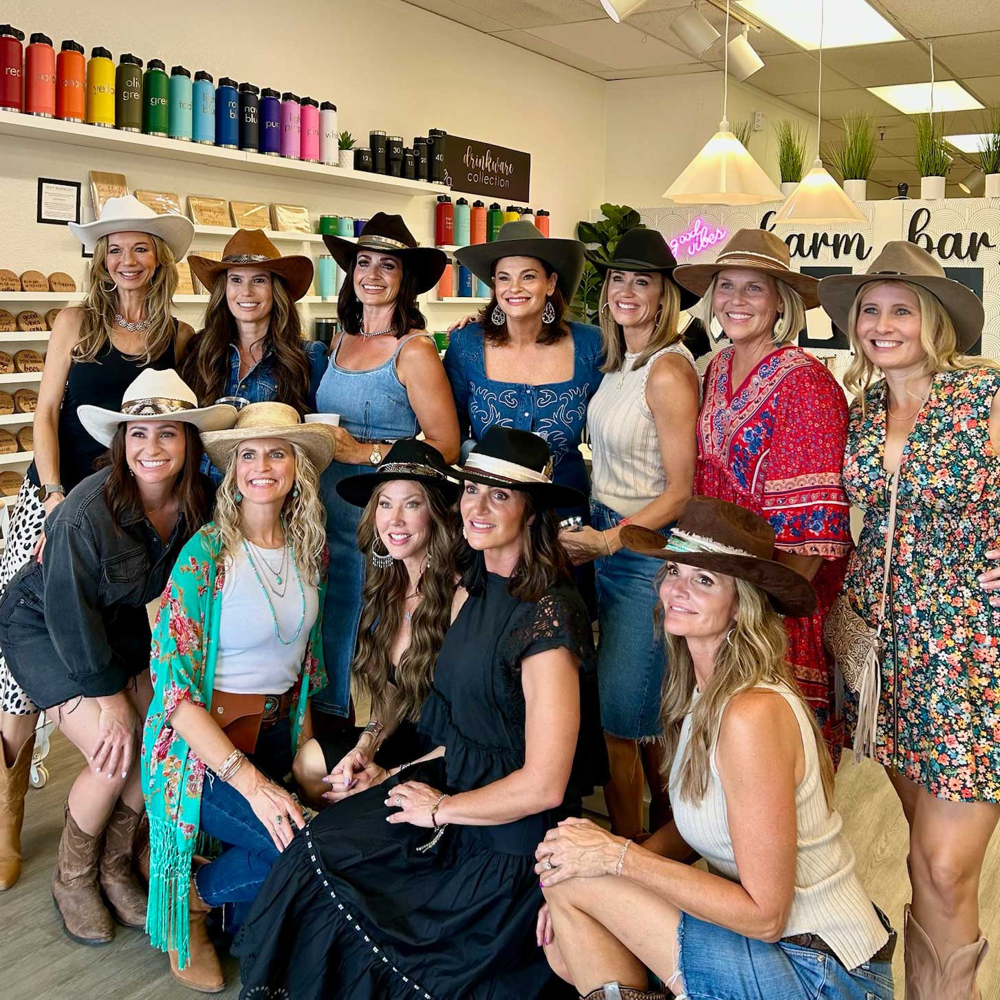 Group of women wearing cowboy hats in Love, Georgie's store with shelves of products in the background.