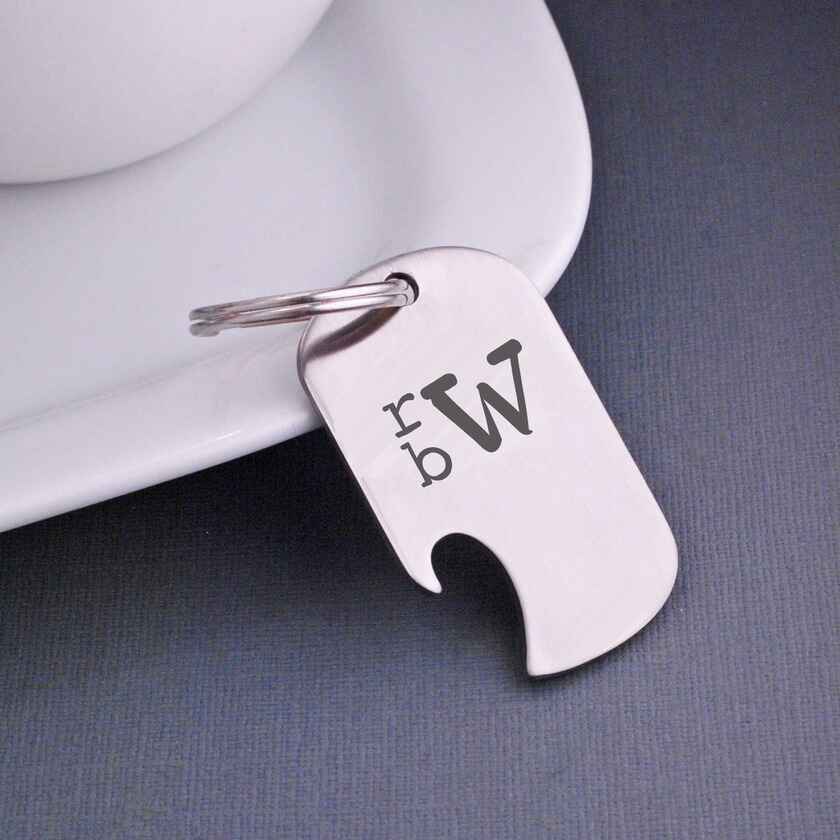 a stainless steel keychain with bottle opener on one side is custom engraved with the monogram "rbW"